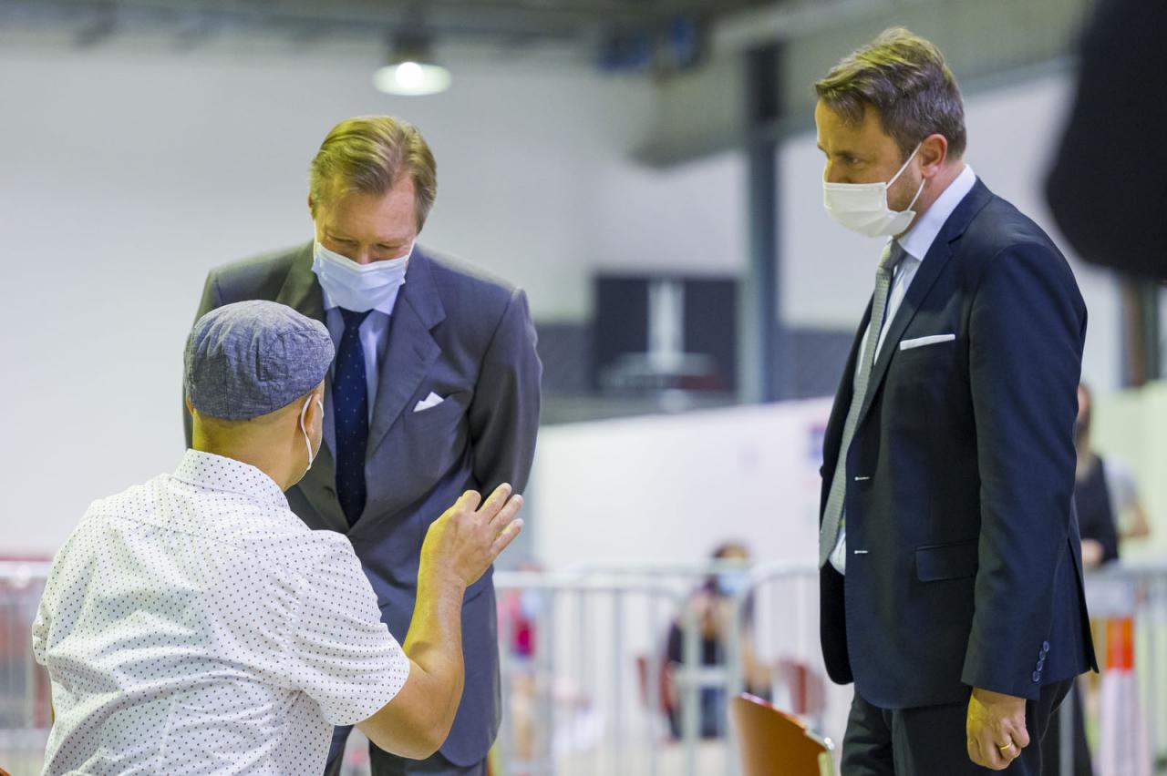 Le Grand-Duc et M. Xavier Bettel échangent avec un visiteur du centre de validation