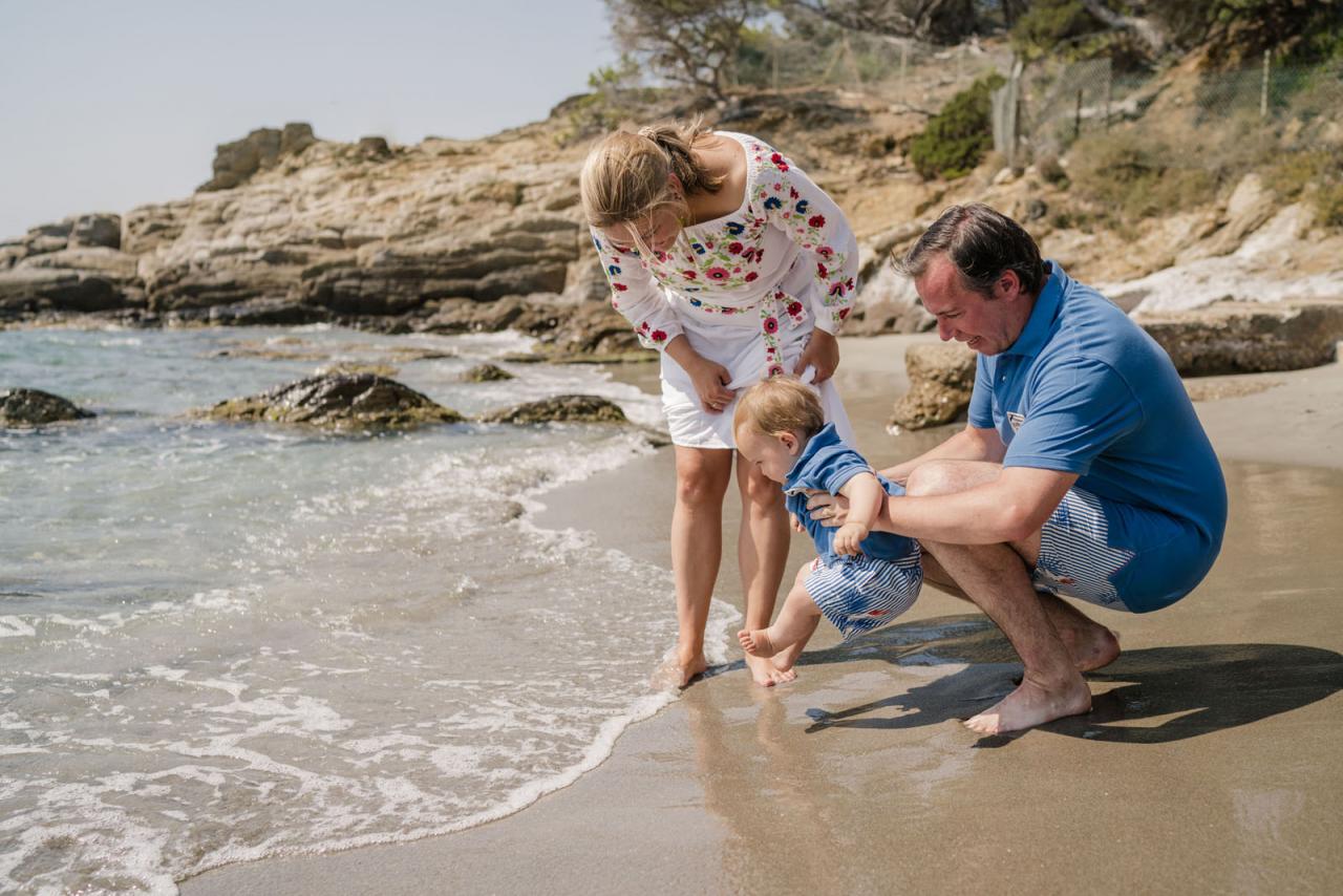 Le Prince Charles, accompagné de ses parents, met ses pieds dans l'eau