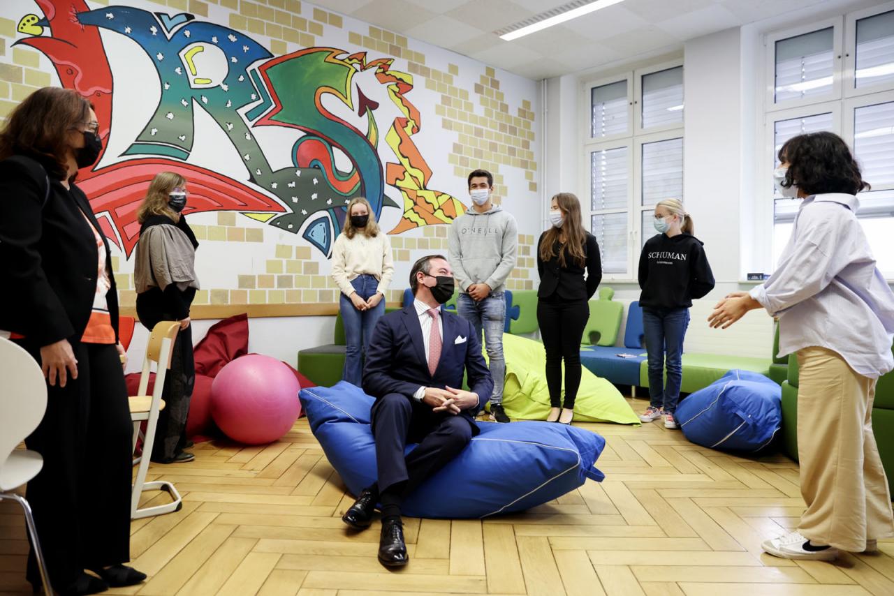 Le Prince Guillaume, installé dans un pouf, échange avec des élèves