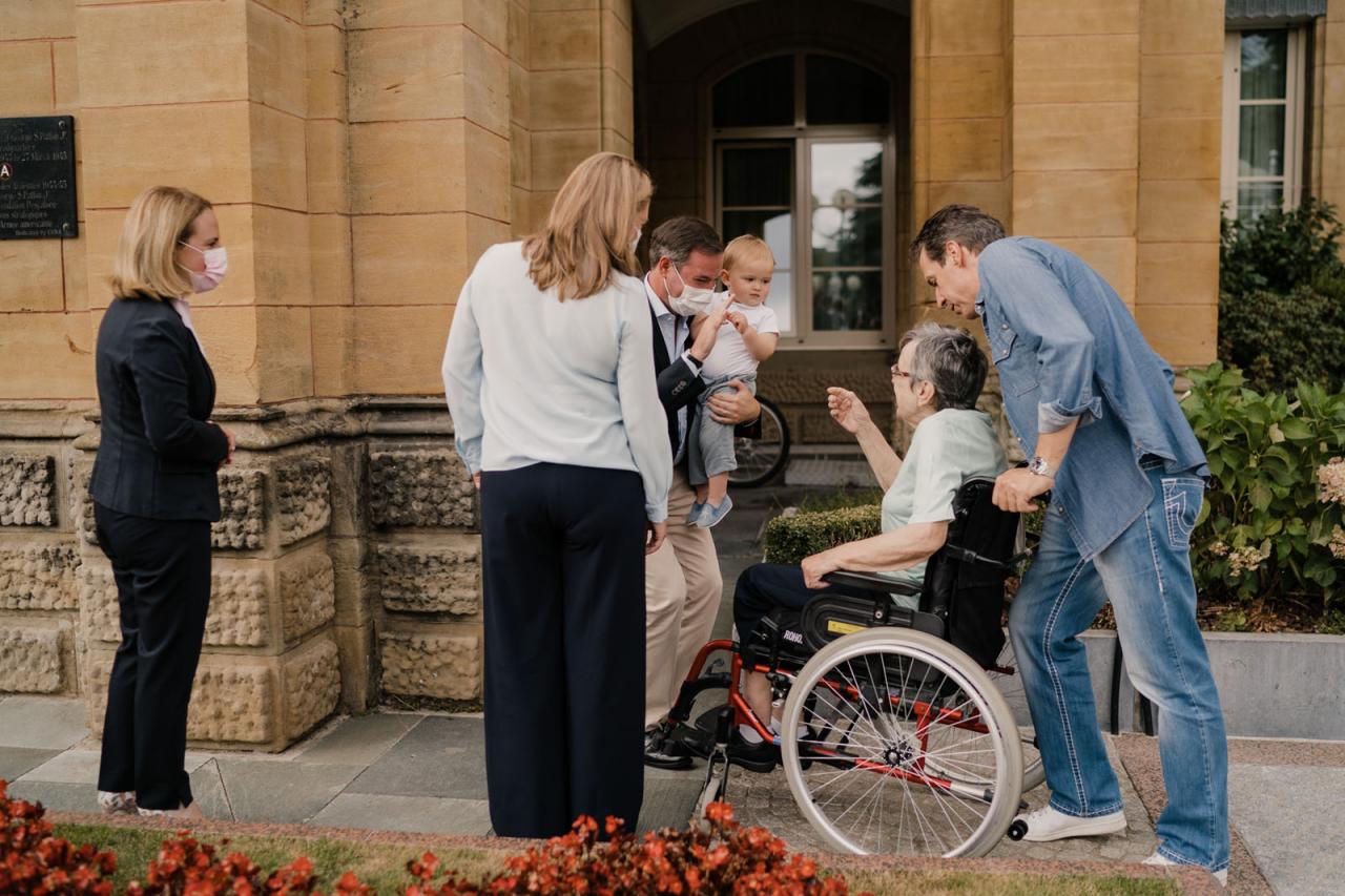 Le Couple héritier et le Prince Charles échange avec une résidente devant la maison de soins