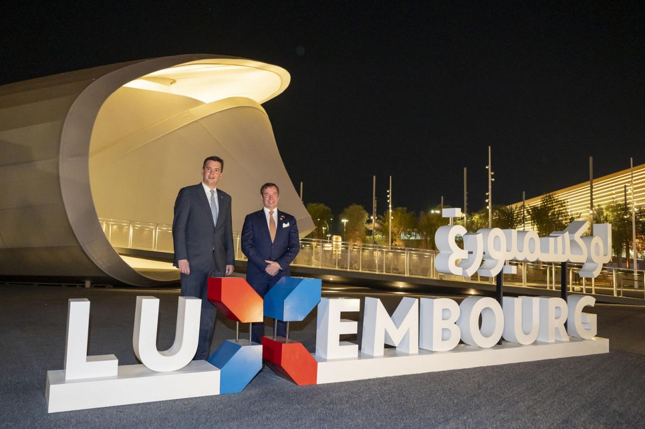 Le Prince Guillaume et le ministre Delles posent devant le pavillon luxembourgeois