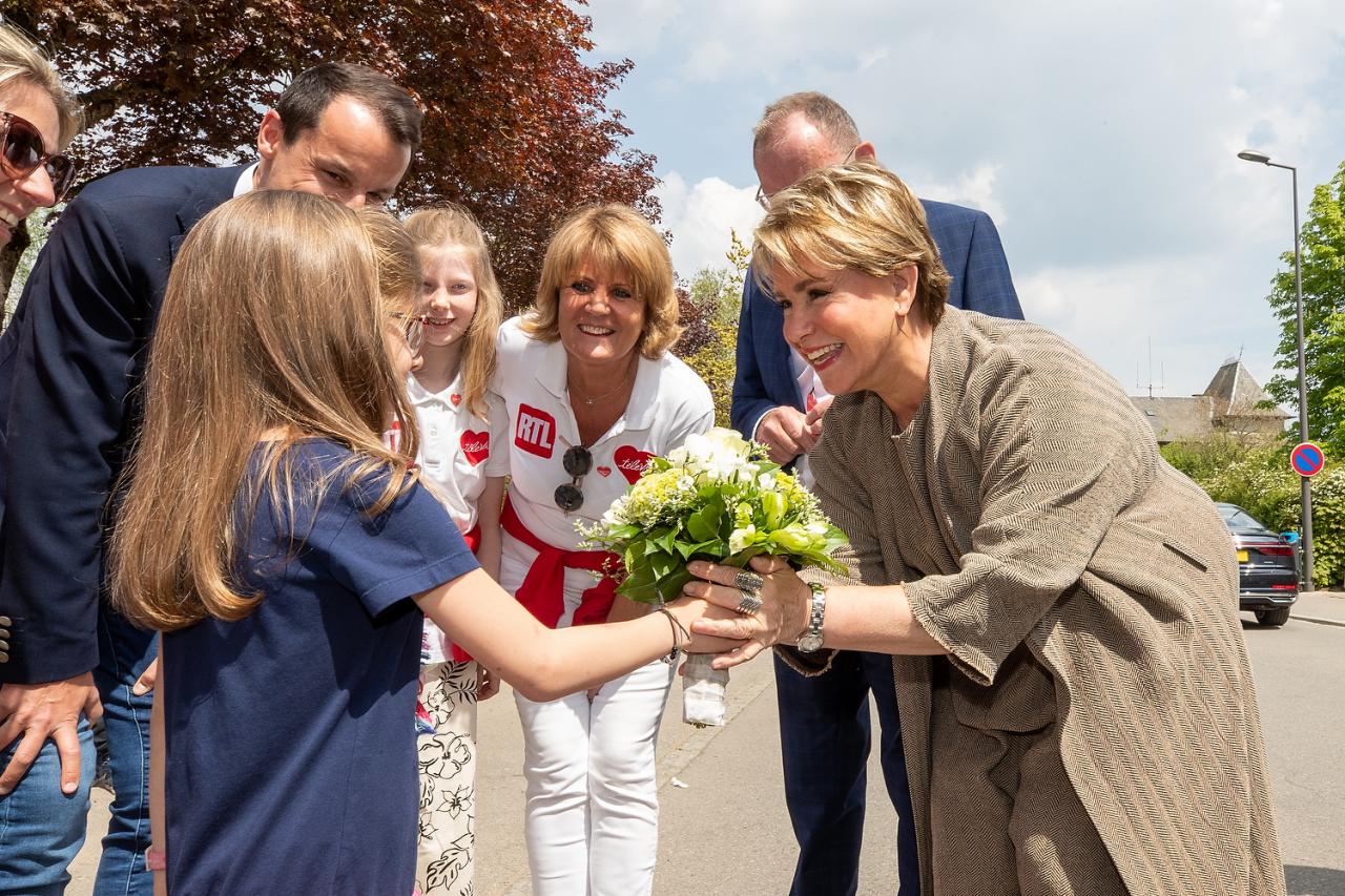 Une fille remet un bouquet de fleurs à la Grande-Duchesse