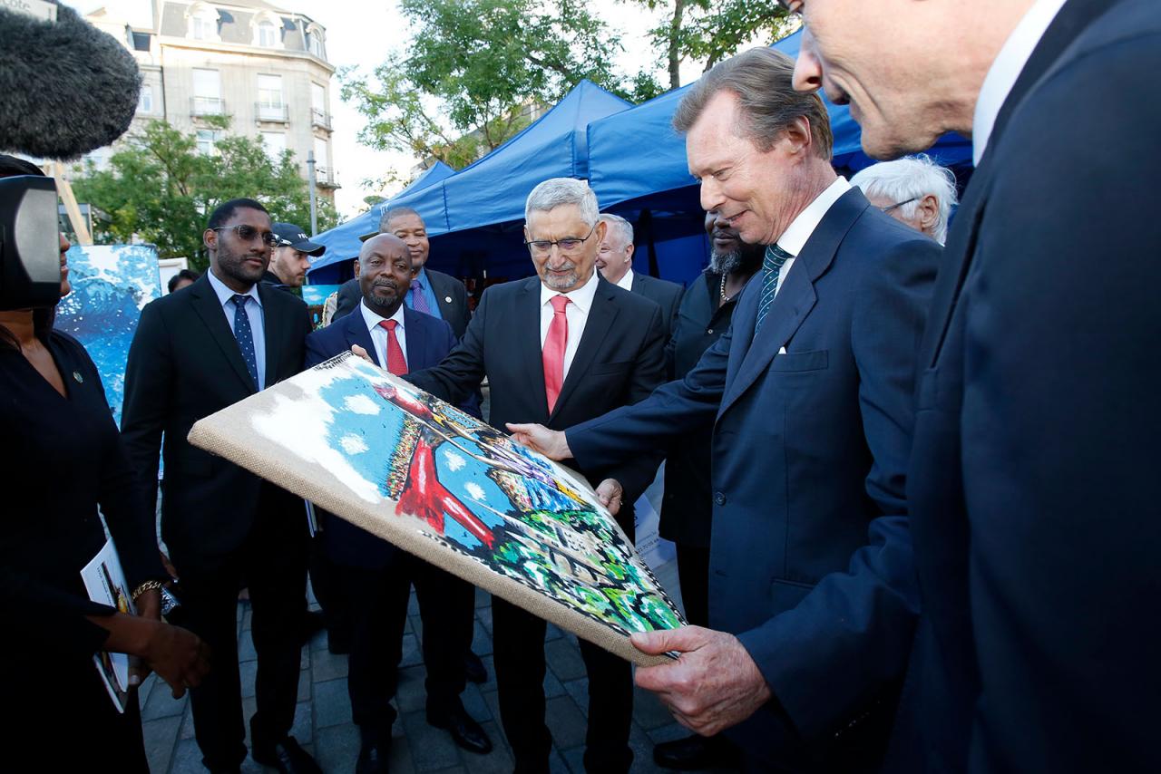 Le Grand-Duc tient et regarde une peinture du Pont Grande-Duchesse Charlotte