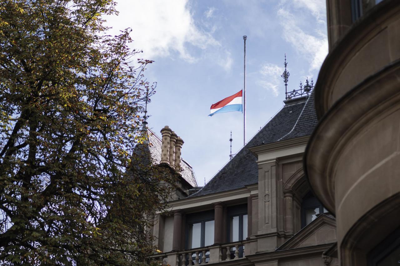 The luxembourgish flag flying at half-mast