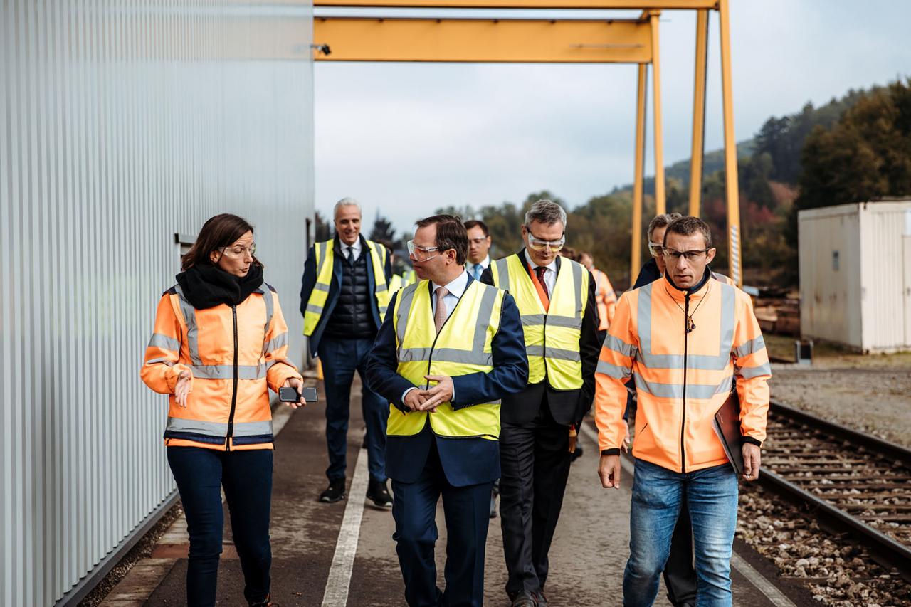 Le Prince et les invités longent l'un des bâtiments Vossloh Cogifer Kihn