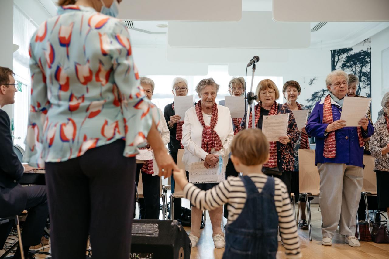 Des résidents chantent devant la Princesse Stéphanie et le Prince Charles