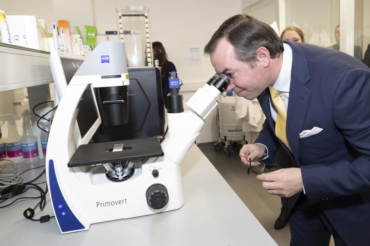 Le Prince observe des échantillons à travers un microscope