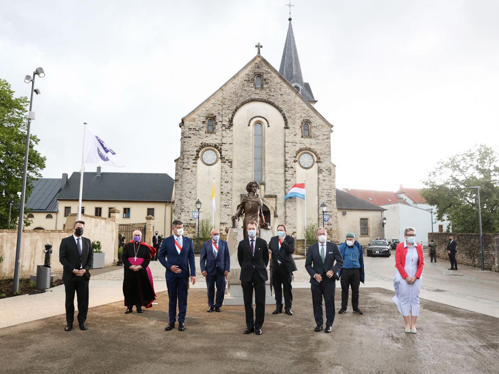 Les invités de la commémoration posent devant le statue de Pierre d'Aspelt