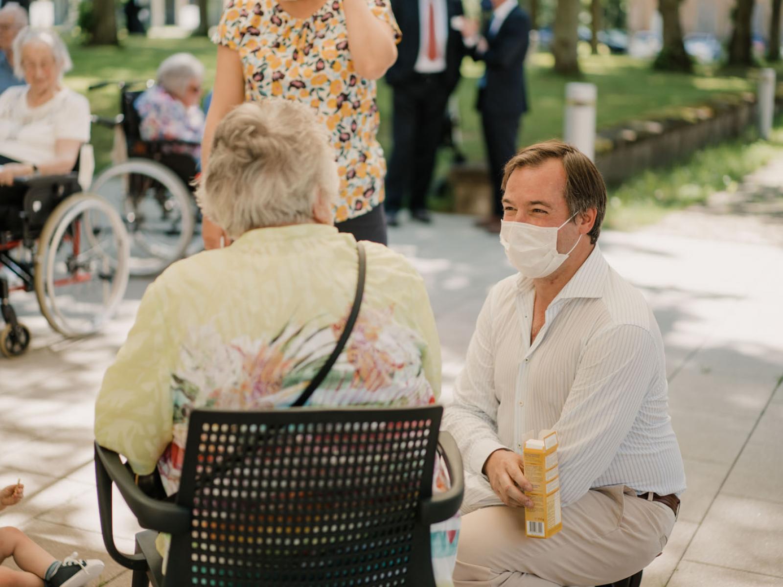 Le Prince Guillaume discute avec une personne âgée dans un parc
