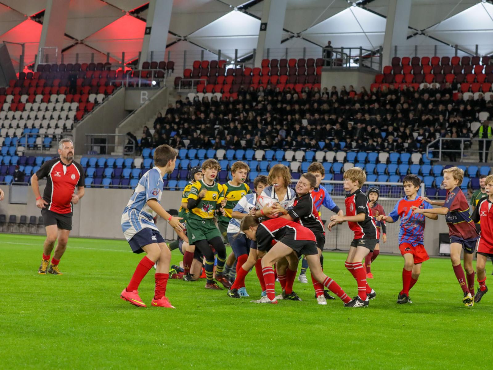 De jeunes joueurs de rugby durant un match dans l'enceinte du stade de Luxembourg