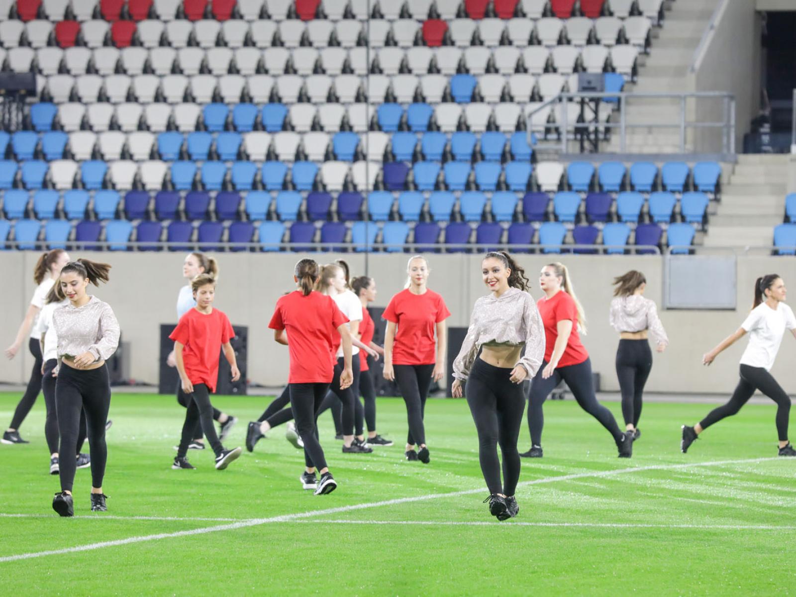 Un groupe de danseuses se produit sur le terrain du stade de Luxembourg