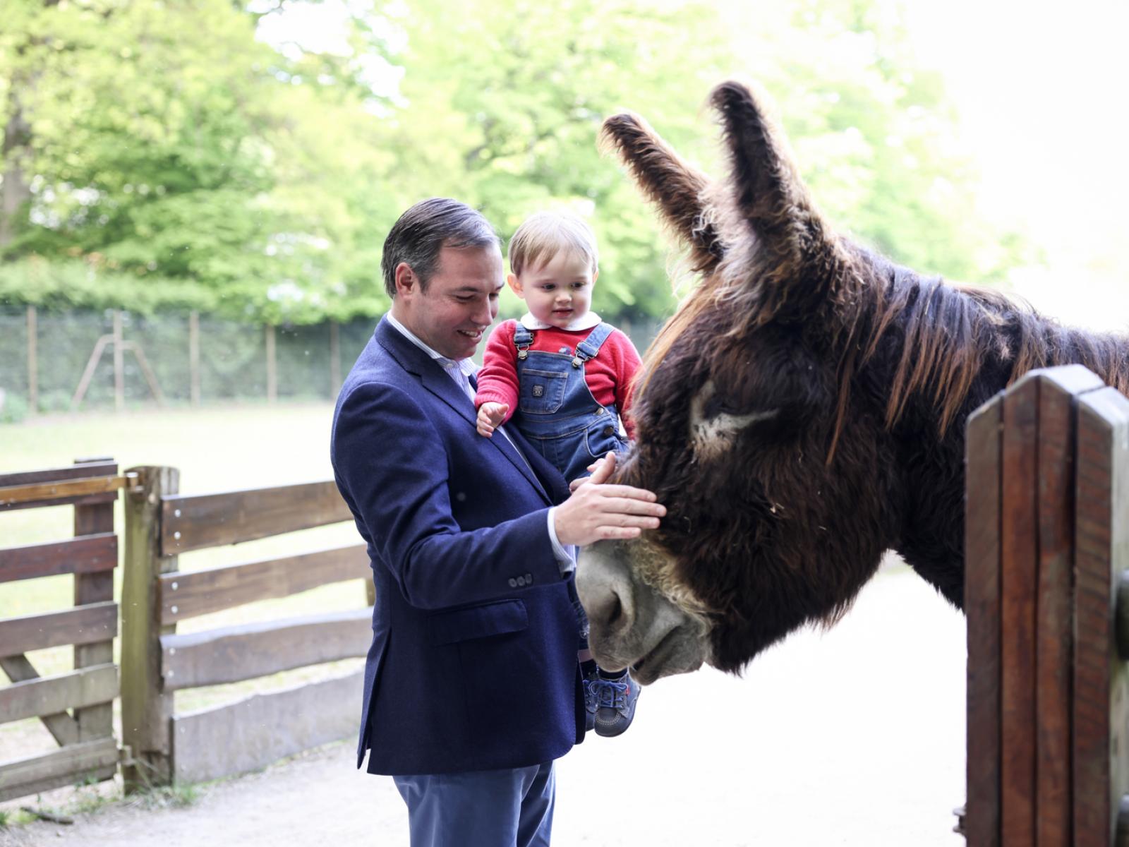 Le Prince héritier et le Prince Charles caressent un âne