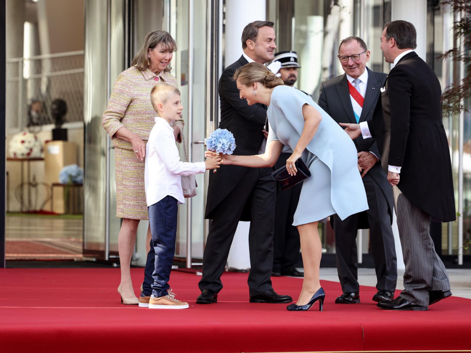 La Princesse Stéphanie reçoit un bouquet de fleurs d'un jeune garçon