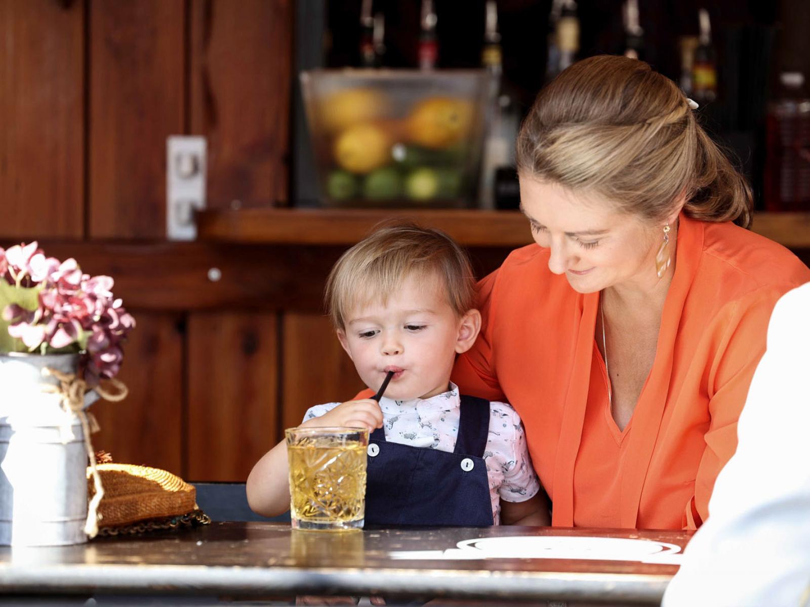 Le Prince boit un jus à côté de sa maman