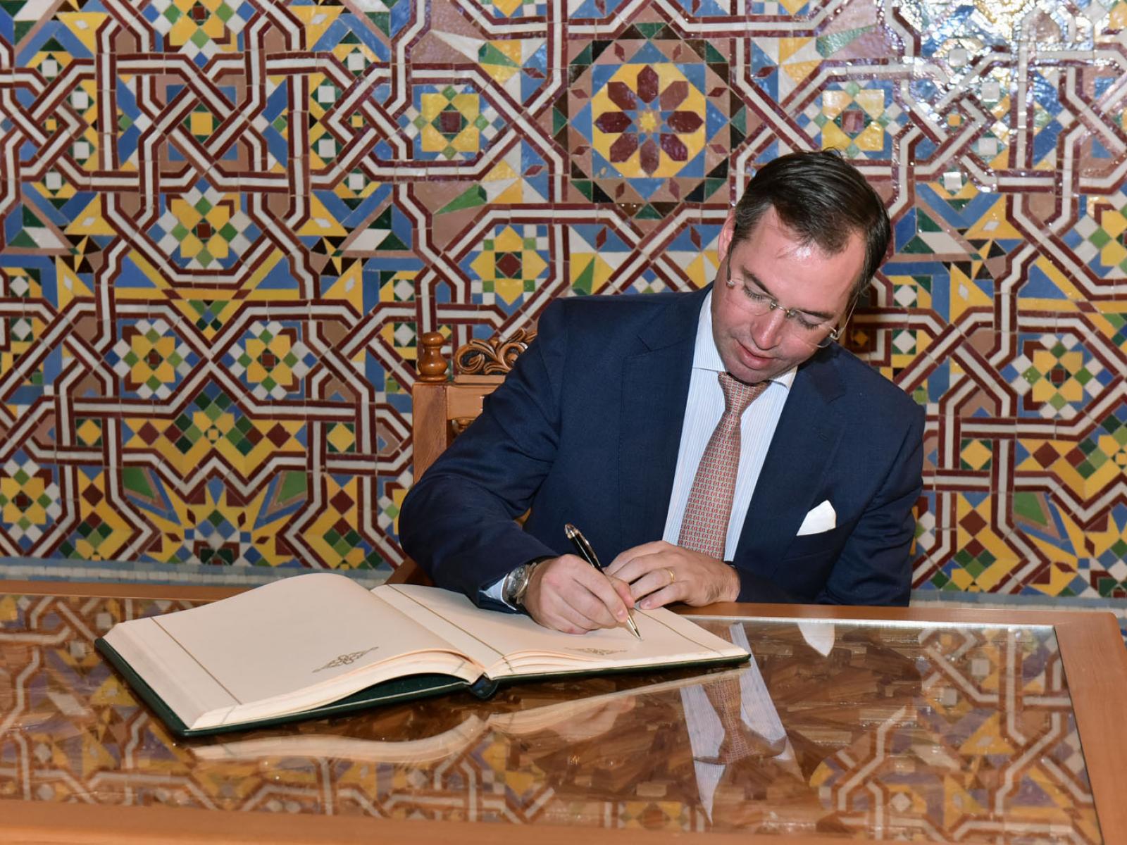 Le Prince signe le livre d'or après la visite de la Mosquée