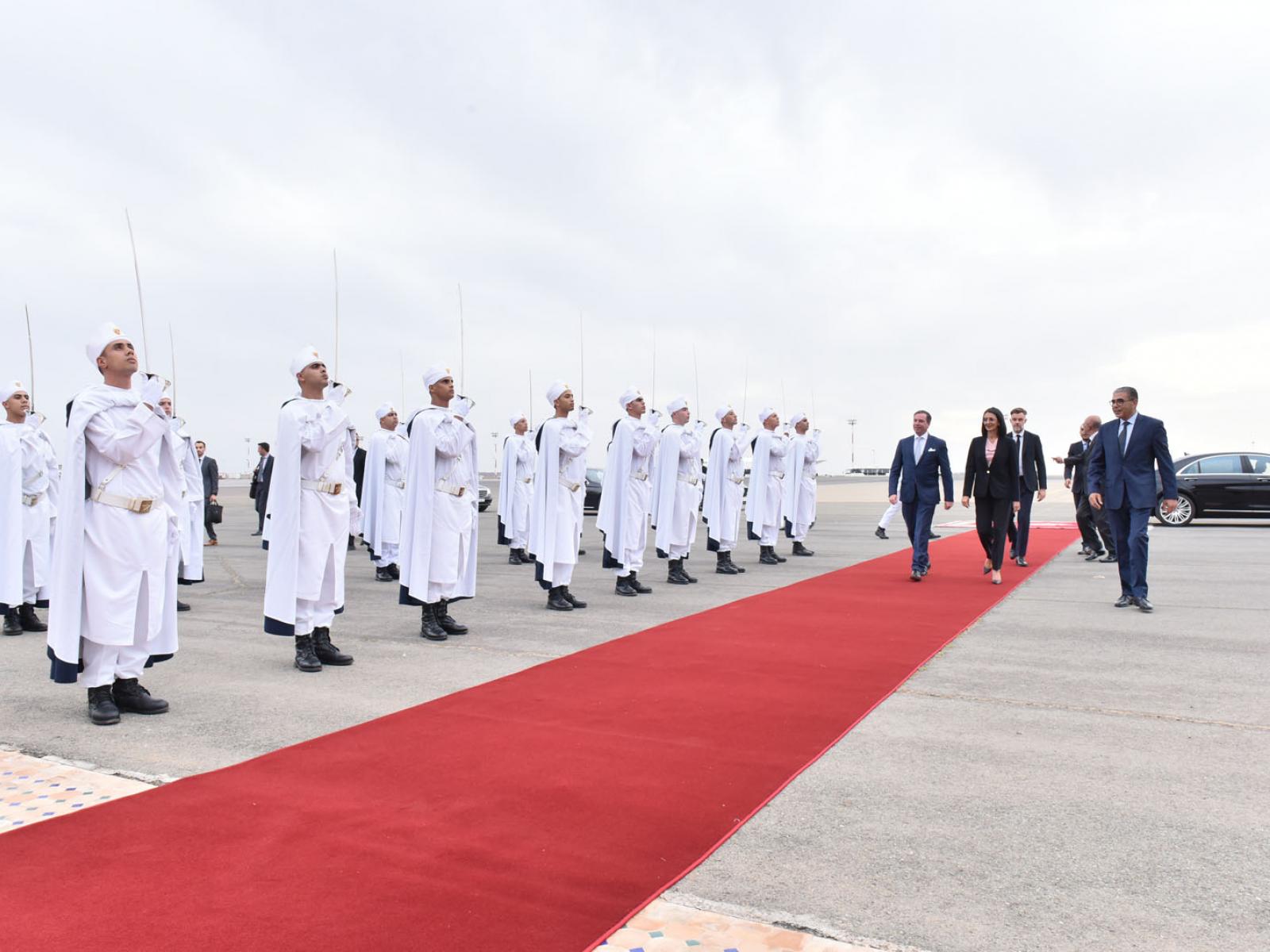 Sur un tapis rouge, le Prince et le ministre sont accueillis à l'aéroport