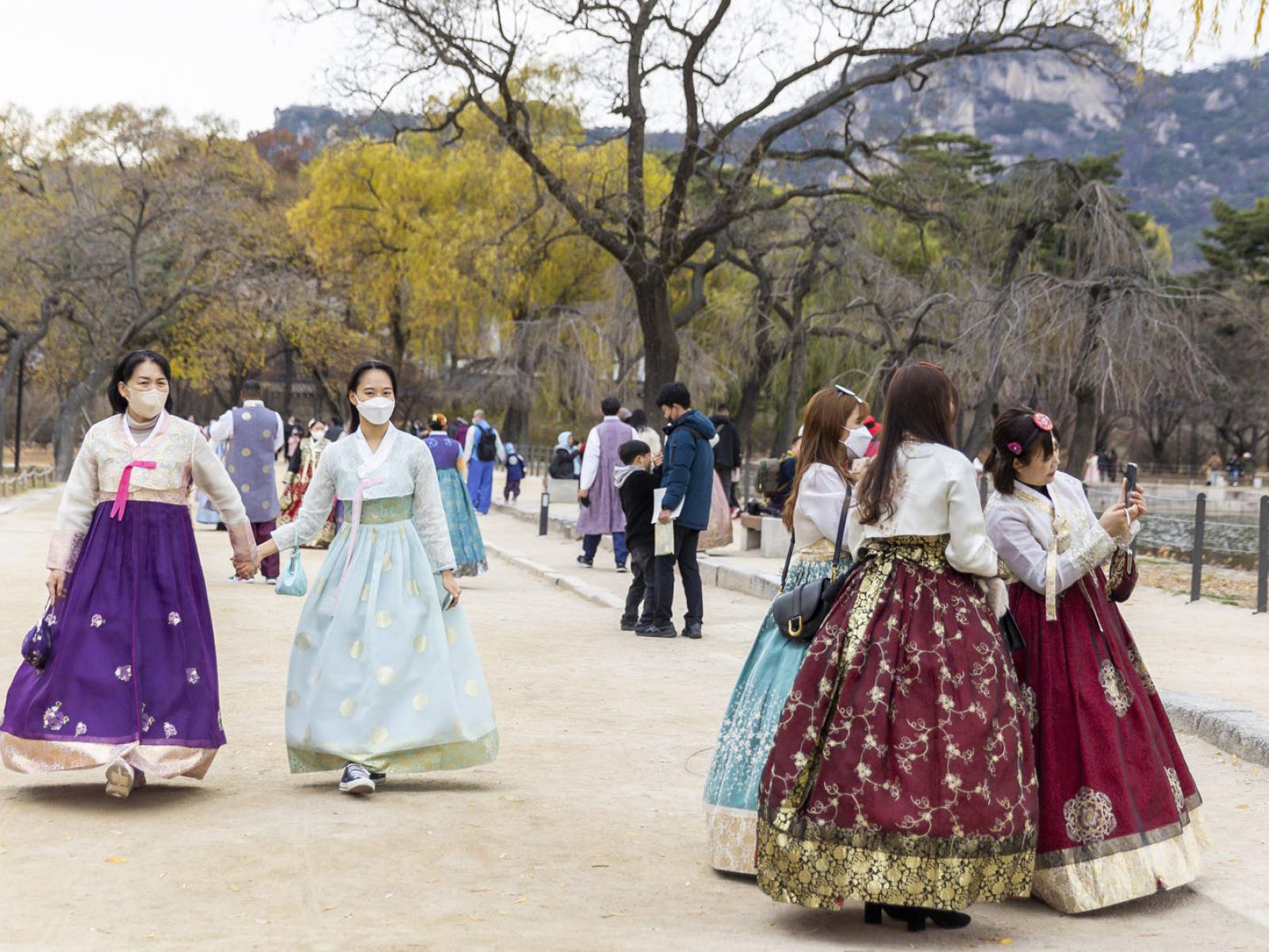 Koreans dressed in traditional attire walking in the Royal Garden 