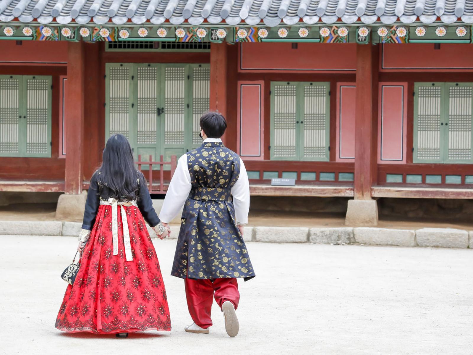 Two Koreans are walking in the Royal Palace in traditional attire