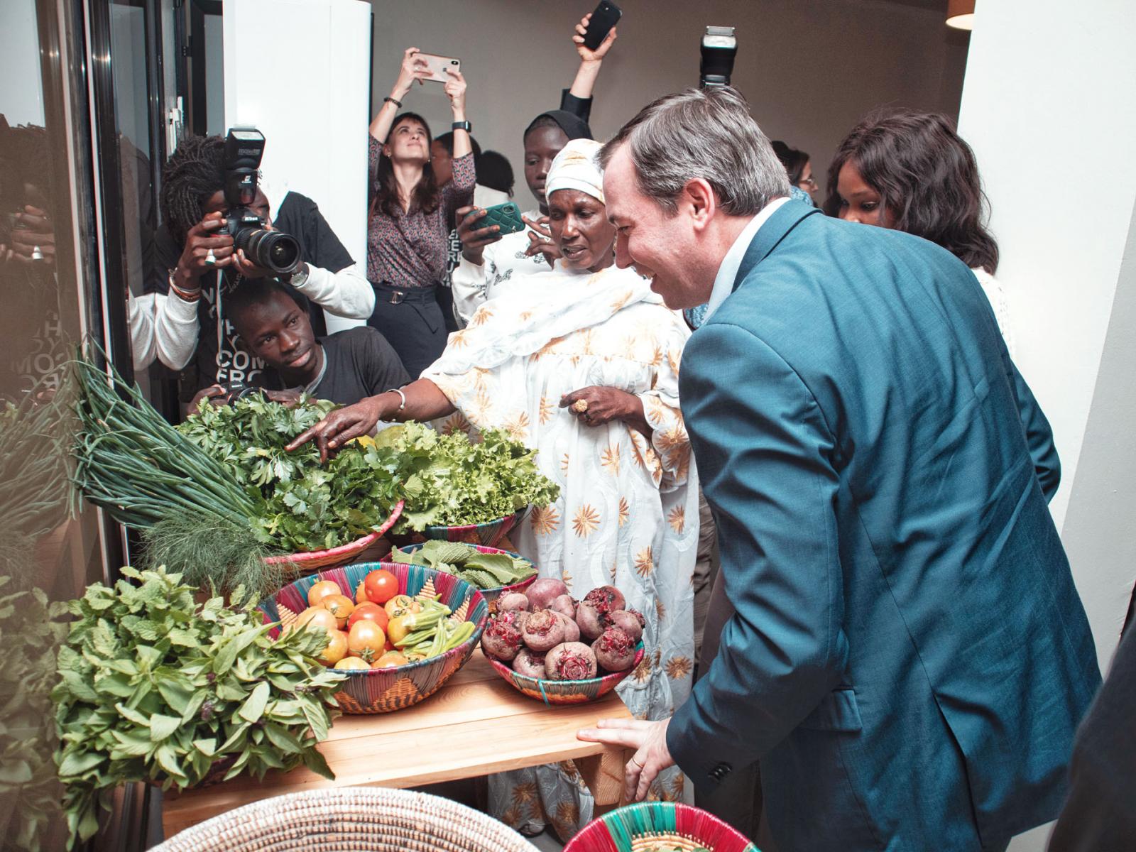 Une femme présente des légumes locaux au Prince