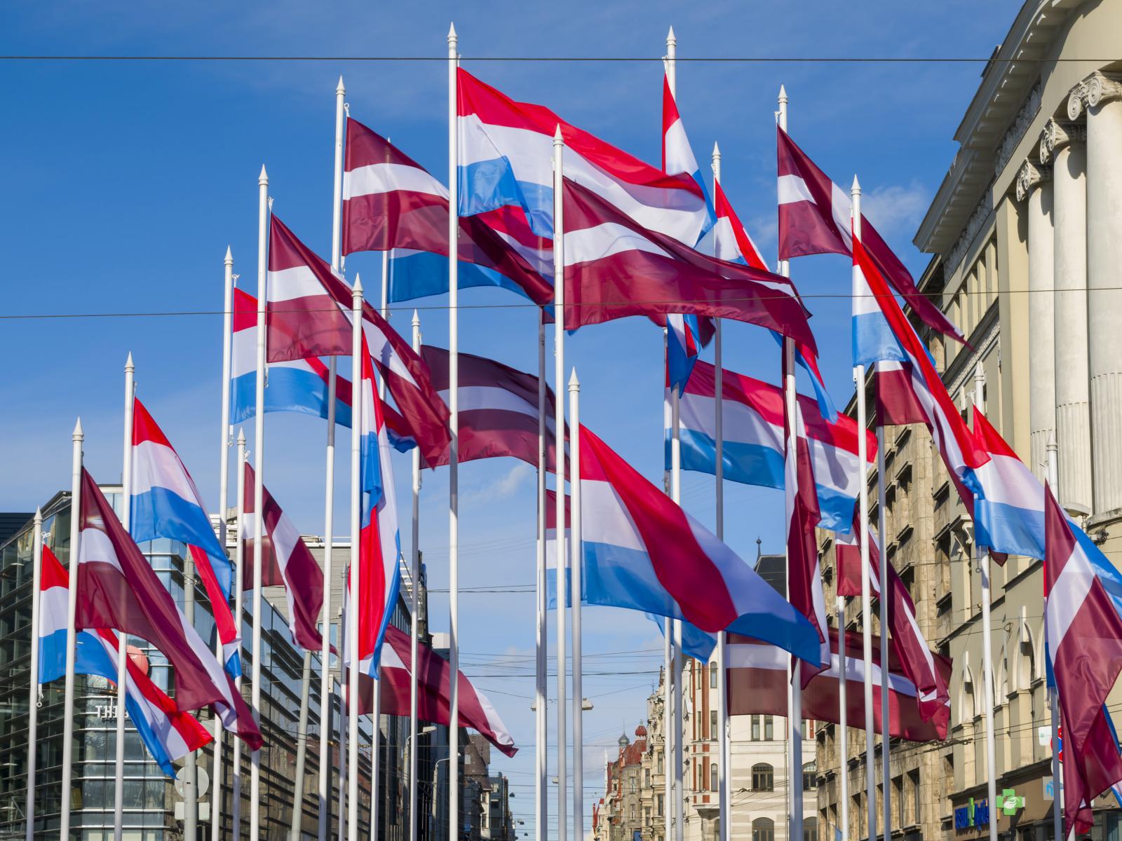 Des drapeaux letton et luxembourgeois flottent