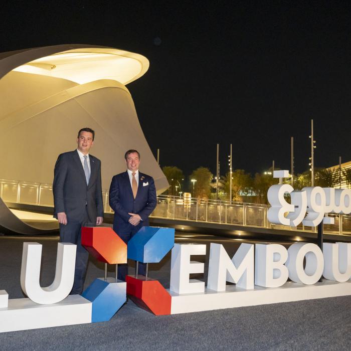 Le Prince Guillaume et le ministre Delles posent devant le pavillon luxembourgeois