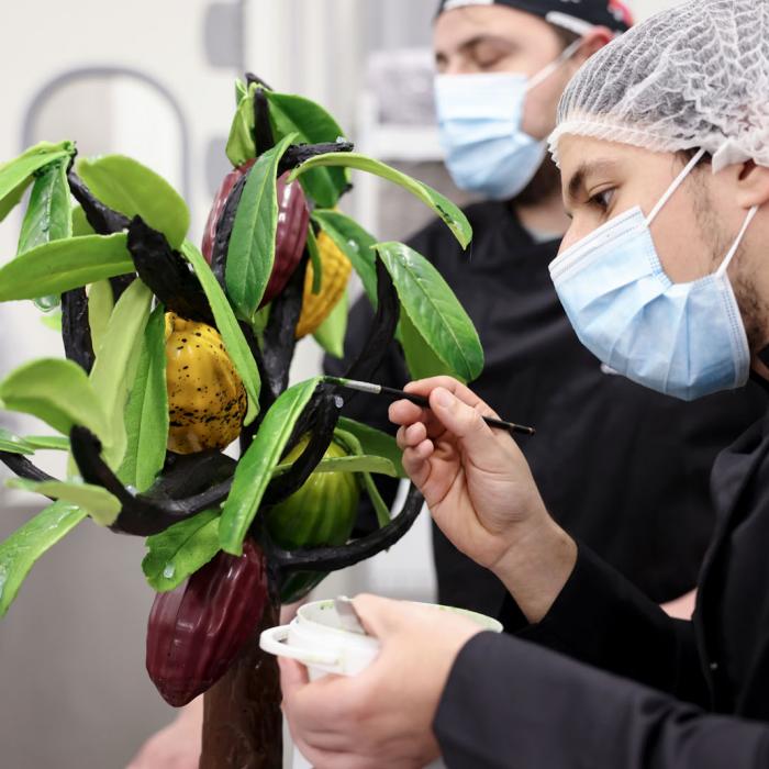 Un artisan travaille sur un arbre réalisé en chocolat