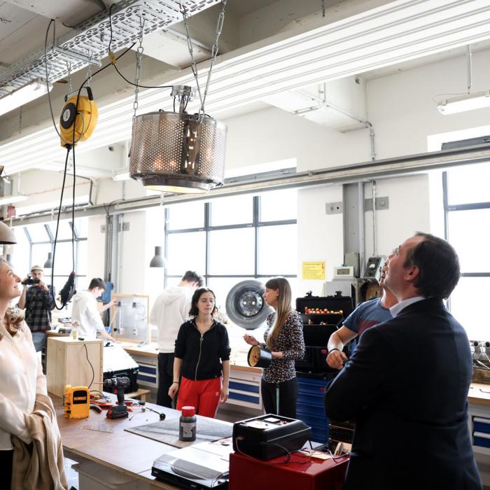 Le Couple héritier observe une lampe réalisée à partir d'un objet recyclé