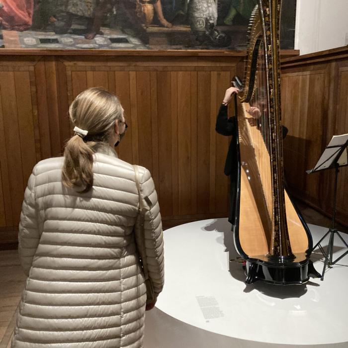 La Princesse devant une personne jouant de la harpe