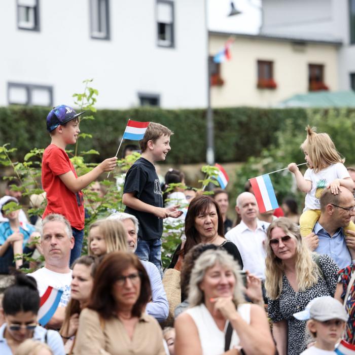 Vue sur deux enfants qui saluent le Couple grand-ducal