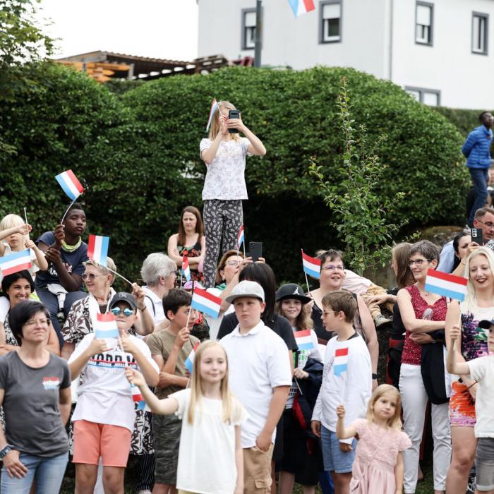 Une jeune fille prend une photo tout en se tenant au dessus de la foule