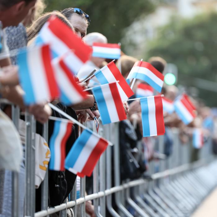 Le public tient des drapeaux luxembourgeois