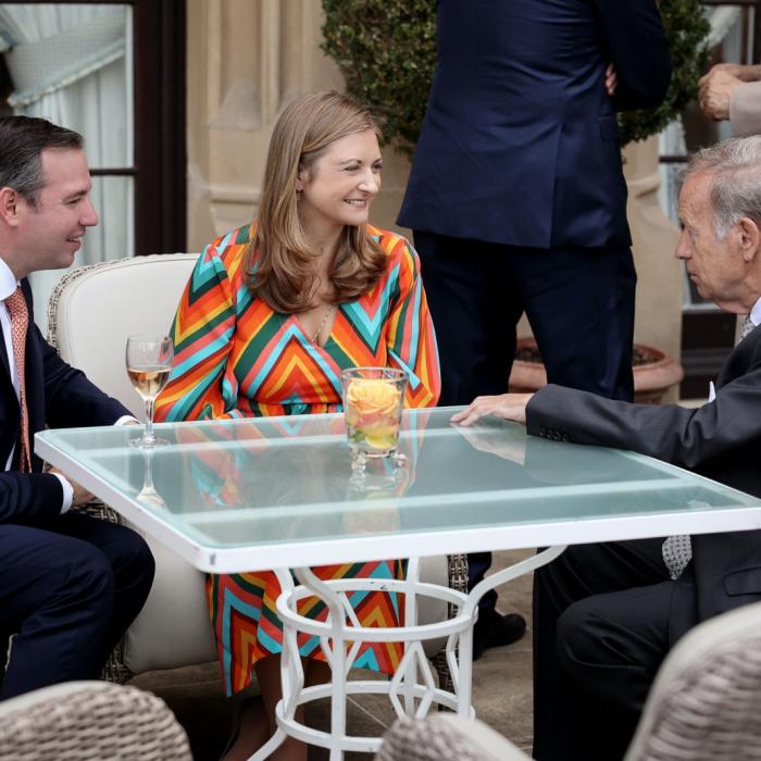 Assis à une table, le Couple héritier en pleine discussion avec un invité