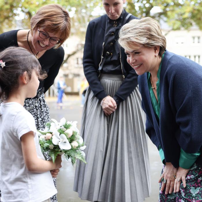 La Grande-Duchesse salue une jeune élève qui tient un bouquet de fleurs