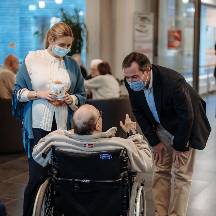 Le Couple héritier discute avec un senior dans un fauteuil roulant