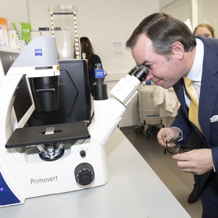 Le Prince observe des échantillons à travers un microscope