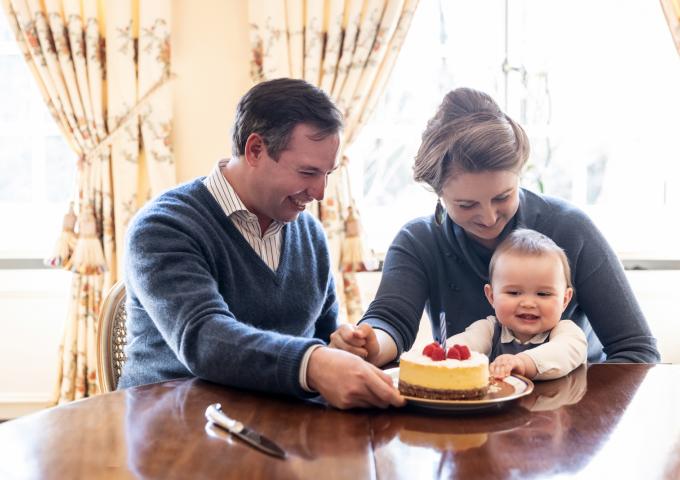Le Prince Charles, entorué de ses parents, découvre son premier gâteau d'anniversaire