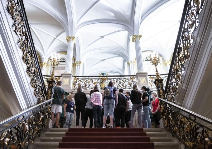 Le groupe de visiteurs fait un arrêt dans l'escalier d'honneur