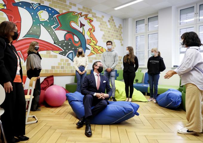 Le Prince Guillaume, installé dans un pouf, échange avec des élèves
