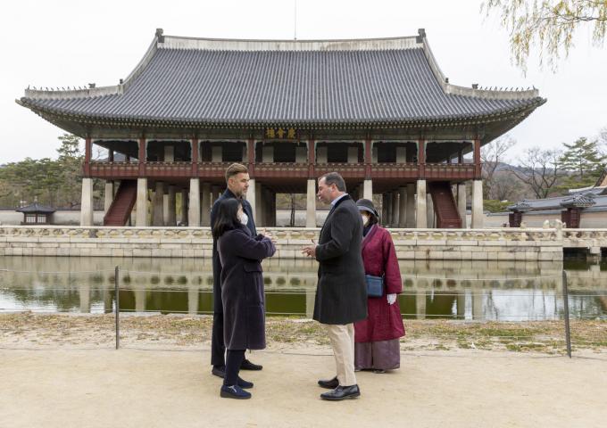 The Prince and the Minister in front of the Palace discussing with guides